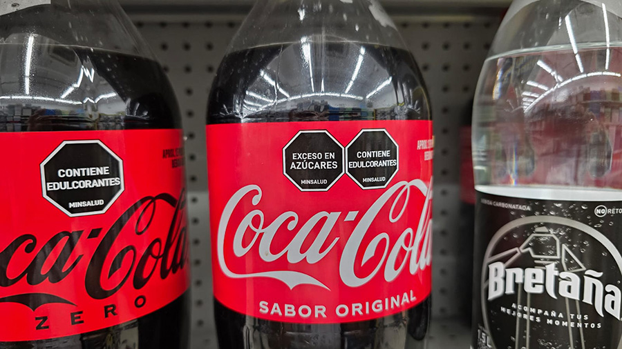 Etiqueta de advertencia de exceso de azúcares en botella de Coca-Cola